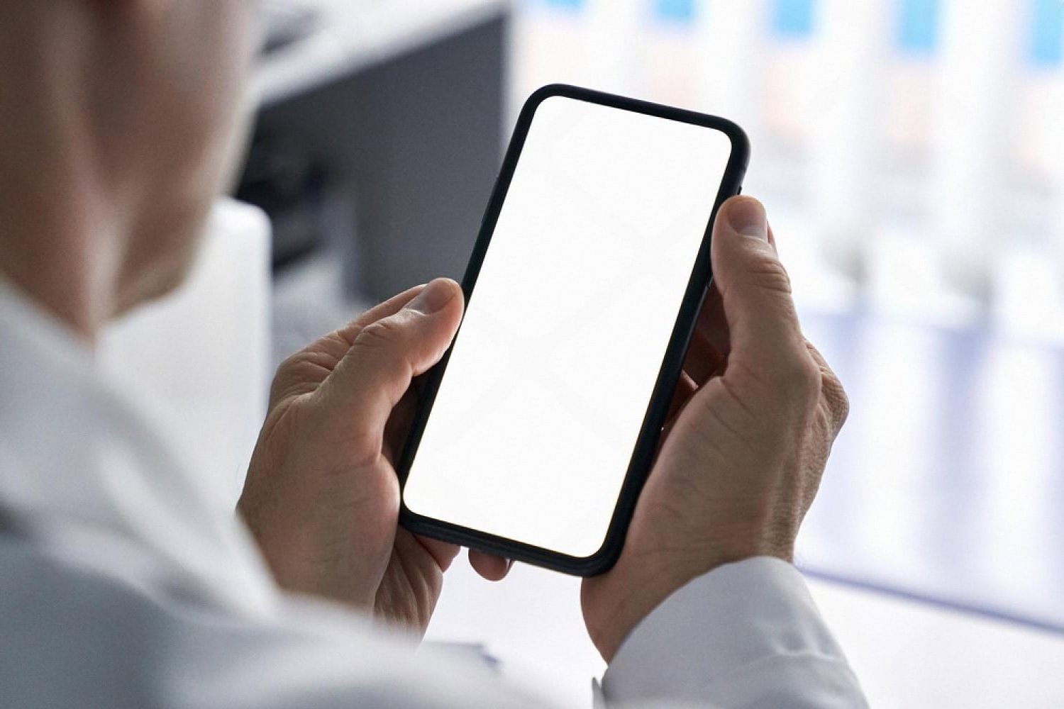 Close-up of a guest holding a smartphone with a blank screen, using a hotel mobile check-in app